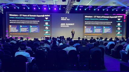 &lsquo;Ninestars &mdash; 27 Years of Domain Expertise&rsquo; slide on stage at AWS Summit Bengaluru 2026.